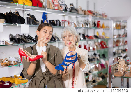 Elderly woman and young woman choosing stilettos in shoe store 111154590
