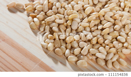 Photo of mix raw pine nut on the wooden desk Photo of mix raw pine nut on the wooden desk 111154836
