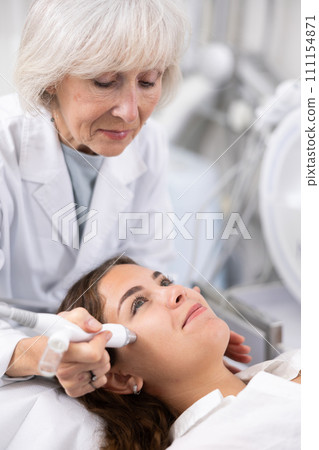 Young woman having face vacuum cleaning procedure Young woman having face vacuum cleaning procedure 111154871