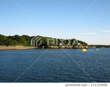 Beach, house on island shore and boats in the waters of Portland Harbor 111154906