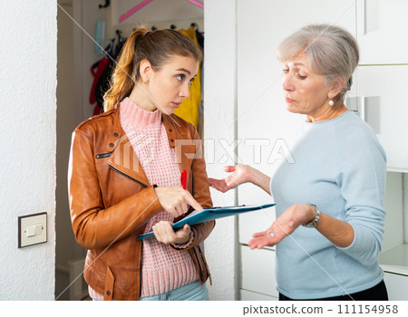 Senior and younger women discussing breach of rent contract 111154958