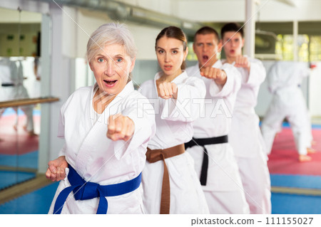 People of different ages performing kata in gym 111155027