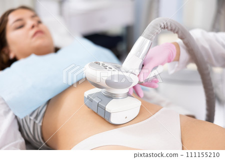 LPG massage device applied on young woman's belly 111155210