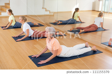 Group of women exercising during yoga class Group of women exercising during yoga class 111155370