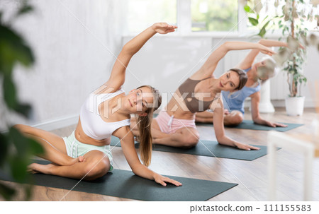 Teenage girl doing yoga in group in studio 111155583
