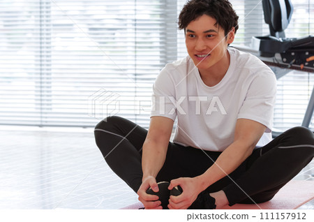 一名男子在運動俱樂部伸展身體 111157912