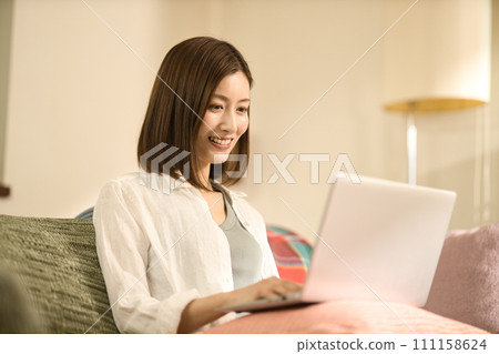 中間女人在客廳裡使用筆記本電腦 111158624