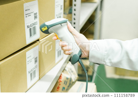 Young woman managing inventory while scanning Faceless 111158789