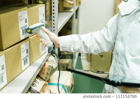 Young woman managing inventory while scanning Faceless 111158790