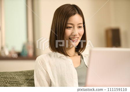 中間女人在客廳裡使用筆記本電腦 中間女人在客廳裡使用筆記本電腦 111159110