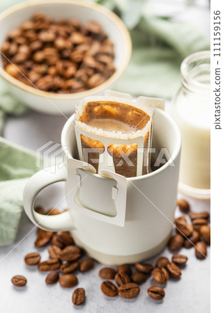 Drip coffee bag with ground coffee in  cup 111159156