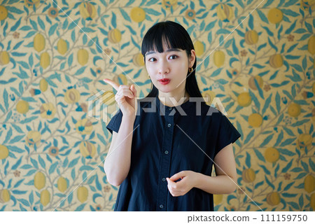 A woman posing to raise her index finger A woman posing to raise her index finger 111159750