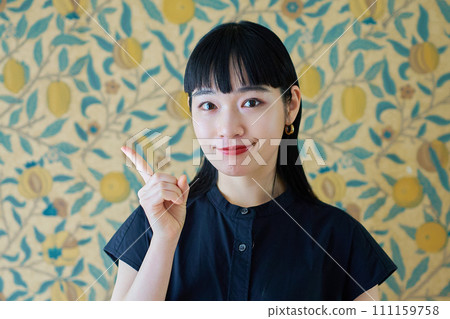 一個女人擺姿勢舉起她的食指 一個女人擺姿勢舉起她的食指 111159758