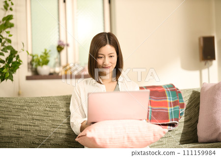 Middle woman using a laptop in the living room Middle woman using a laptop in the living room 111159984