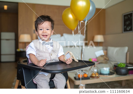 Baby boy's first birthday with cake in balloons 111160634