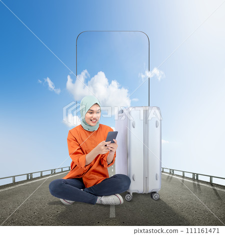 Asian girl in a scarf sitting with a suitcase while using a mobile phone on the street with a sky view on the mobile phone screen Asian girl in a scarf sitting with a suitcase while using a mobile phone on the street with a sky view on the mobile phone screen 111161471