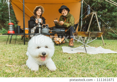 男性和女性露營者與狗和寵物在秋季/冬季露營地露營 男性和女性露營者與狗和寵物在秋季/冬季露營地露營 111161871