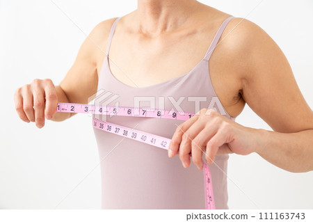 Middle-aged woman measuring her bust 111163743
