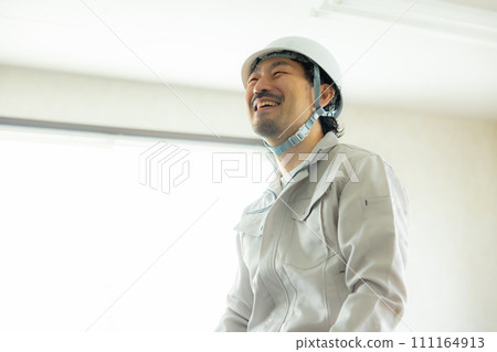 一名穿著工作服的男子正在檢查天花板 111164913
