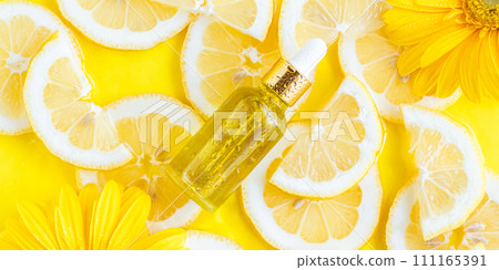 Essential oil, serum on textured background with yellow lemon slice Essential oil, serum on textured background with yellow lemon slice 111165391