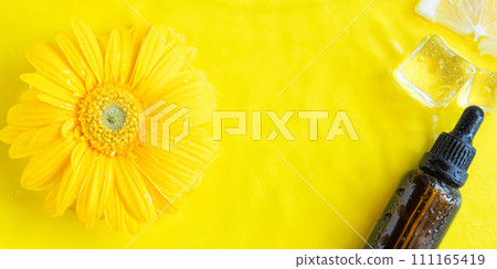 Dark glass essential oil, vitamin C serum on yellow background 111165419