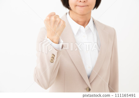 Middle-aged woman in a suit doing a fist pump Middle-aged woman in a suit doing a fist pump 111165491