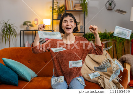 Woman celebrating success winning lottery jackpot money cash dollar rain falling on girl at home 111165499