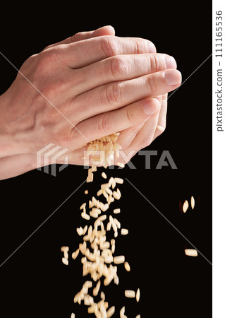 A hands hold a pile of rice, symbolizing charity, love, and hope. With cultural 111165536