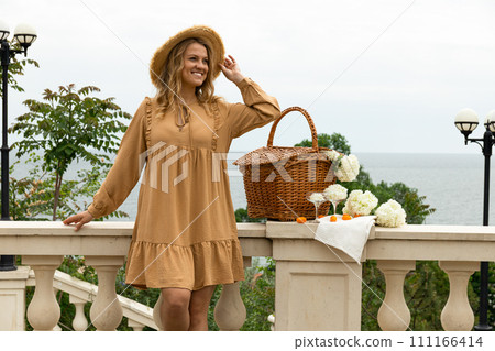 Beautiful girl with flowers on the street in summer. 111166414