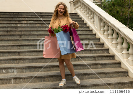 Young girl with paper bags, with flowers. 111166416