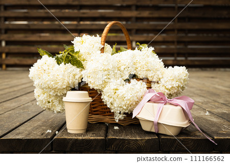 Coffee with flowers on the street, on a wooden background. 111166562