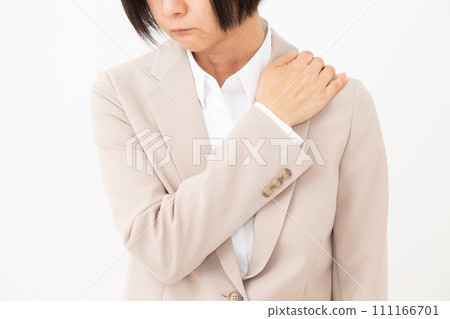 A middle-aged woman in a suit suffering from stiff shoulders A middle-aged woman in a suit suffering from stiff shoulders 111166701
