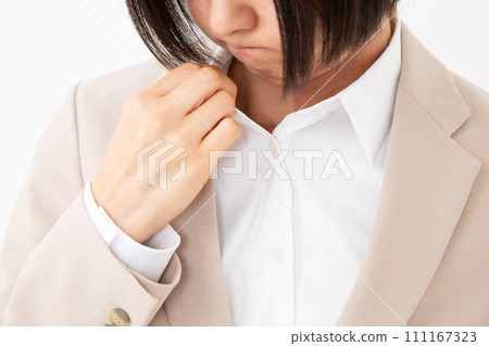 A middle-aged woman in a suit who is concerned about body odor 111167323