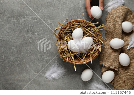 Eggs in a wicker basket, on a gray background. 111167446