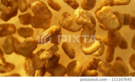 Falling Nuggets Isolated on Golden Background, Selective Focus. Concept of Flying Food. Falling Nuggets Isolated on Golden Background, Selective Focus. Concept of Flying Food. 111167645