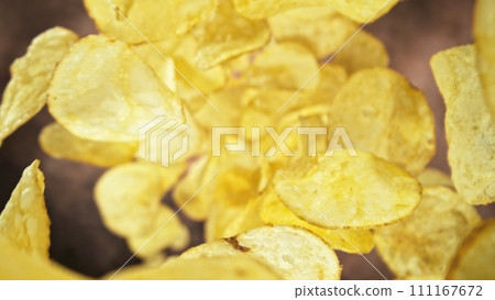 Flying Fried Potato Chips Levitating in the Air. Concept of Flying Junk Food. Selective Focus. Flying Fried Potato Chips Levitating in the Air. Concept of Flying Junk Food. Selective Focus. 111167672