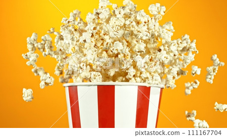 Popcorn Flying up in the Air from Paper Bucket. 111167704