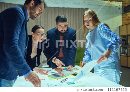 Group of professionals, colleagues engaged in strategic planning session with graphs and charts. Launching startup, working with analytics 111167853