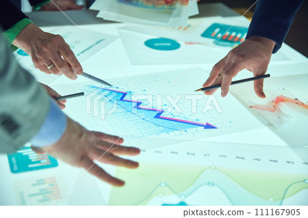 Employees working on project development, looking on digital documents on table. Growing analytical arrow, charts, statistics and data Employees working on project development, looking on digital documents on table. Growing analytical arrow, charts, statistics and data 111167905