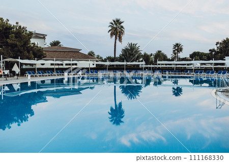 beach holiday near the pool. reflection of palm trees in the pool. relaxation on the hotel grounds. Mediterranean Sea. Turkey beach holiday near the pool. reflection of palm trees in the pool. relaxation on the hotel grounds. Mediterranean Sea. Turkey 111168330