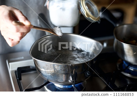 Adding salt to boiling water in a pot Adding salt to boiling water in a pot 111168853