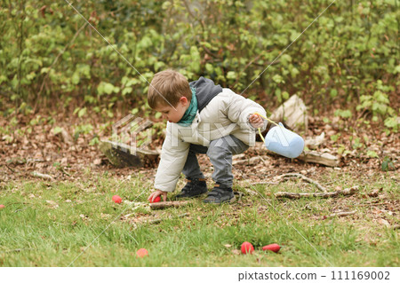 A boy looking for eggs in a bag for Easter A boy looking for eggs in a bag for Easter 111169002