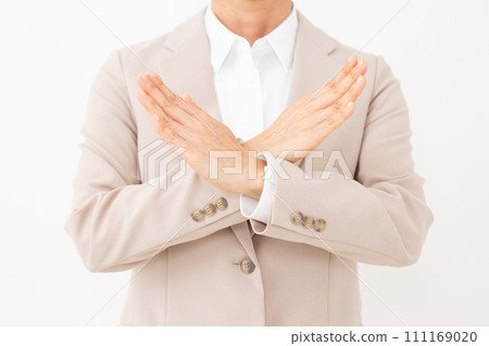 一位身穿米色西裝的中年婦女用手打十字標誌 一位身穿米色西裝的中年婦女用手打十字標誌 111169020