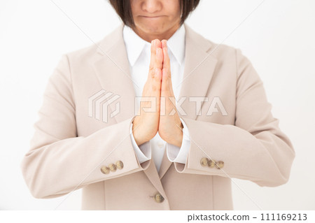 身穿米色西裝的中年婦女雙手合十許願 111169213