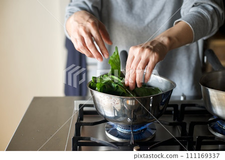 Boiling spinach with salt in a pot Boiling spinach with salt in a pot 111169337