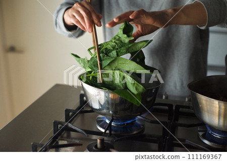 Boiling spinach with salt in a pot Boiling spinach with salt in a pot 111169367