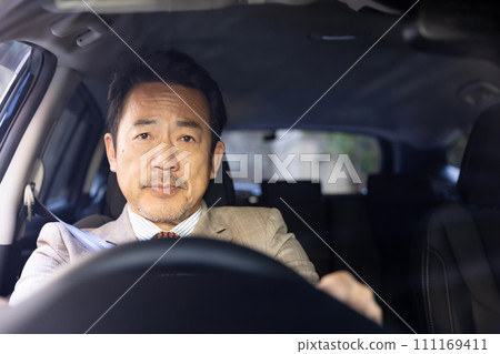 Businessman driving a car Businessman driving a car 111169411