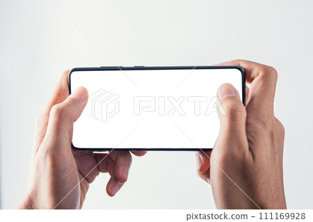 Hand holding mobile phone with white blank screen mockup for playing game screen 111169928