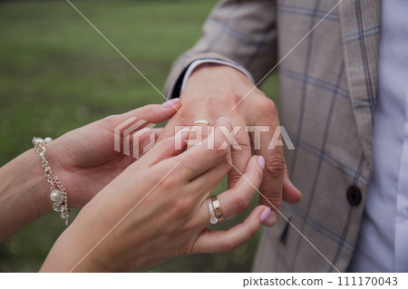the groom and the bride put rings on their hands 111170043