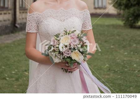 bride with a bouquet of flowers in the park 111170049